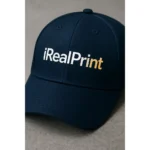 Șapcă albastru navy personalizată cu nume – detaliu text alb-auriu pe material închis, personalizare clară și elegantă