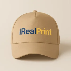 Șapcă crem personalizată cu logo iRealPrint – design profesional pe fundal crem, branding vizibil și elegant