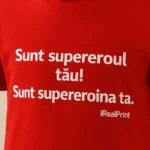 Tricou copii personalizat roșu, detaliu print „Sunt supereroul tău / Sunt supereroina ta”, personalizare transfer termic iRealPrint, text clar și vizibil pe fundal vibrant.
