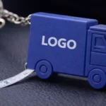 Detaliu breloc camion albastru cu personalizare logo și ruletă integrată, produs promoțional pentru branding logistic