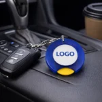 Breloc cu fisă de cumpărături albastru personalizat folosit pe chei în interior auto, exemplu real de utilizare zilnică și expunere constantă a brandului