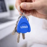 Breloc cu fisă din plastic albastru personalizat utilizat pe chei, exemplu real de folosire zilnică pentru expunere naturală și branding constant