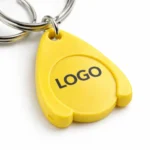 Prim-plan breloc cu fisă din plastic galben pentru cărucior personalizat, detaliu print logo clar, suprafață optimă pentru branding promoțional cu vizibilitate ridicată