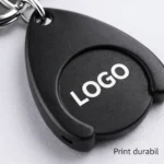 Prim-plan breloc cu fisă din plastic negru personalizat, detaliu print durabil și suprafață optimă pentru logo, ideal pentru campanii promoționale corporate