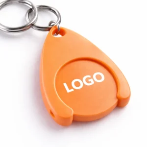 Breloc cu fisă din plastic portocaliu personalizat folosit pe chei, exemplu real de utilizare zilnică pentru expunere constantă a brandului în contexte comerciale