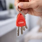 Breloc cu fisă din plastic roșu personalizat folosit pe chei, exemplu real de utilizare zilnică pentru branding constant în contexte comerciale