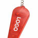 Detaliu macro breloc cu fluier și lanternă roșu, accent pe zona de personalizare logo și design transparent multifuncțional