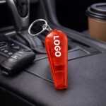 Breloc cu fluier și lanternă roșu personalizat, utilizare lifestyle în interior auto, obiect promoțional vizibil pentru reacție rapidă