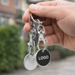 Breloc negru cu fisa metalica pentru carucior atasat la chei, accesoriu promoțional folosit zilnic pentru expunere constanta a brandului