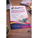Flyer personalizat A4 pentru servicii de tipar iRealPrint prezentat pe birou într-un context profesional de lucru, sugerând utilizarea în promovarea afacerilor și serviciilor.
