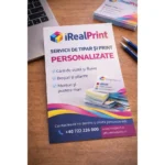 Flyer A6 personalizat pentru servicii de tipar și print iRealPrint prezentat pe birou în context de lucru profesional pentru promovarea materialelor publicitare.