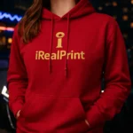 Hanorac rosu personalizat dama cu logo iRealPrint, cadru close-up in ambient urban nocturn, evidentiind contrastul si impactul vizual