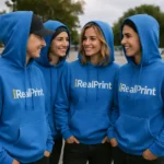 Grup de persoane purtând hanorace albastru regal personalizate, evidențiind unitatea echipei și vizibilitatea brandului