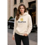 Model feminin purtând hanorac crem nisip personalizat iRealPrint într-un cadru urban elegant, stil premium și rafinat