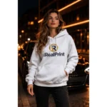 Model feminin purtând hanorac alb personalizat iRealPrint în cadru urban de noapte, stil modern și elegant