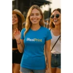 Femeie purtând tricou damă personalizat albastru cu logo iRealPrint în context lifestyle outdoor, exemplu de utilizare casual și branding vizibil