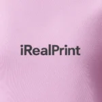 Detaliu personalizare logo iRealPrint aplicat prin transfer termic pe tricou damă personalizat roz orhidee, evidențiind textura materialului