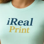 Detaliu personalizare logo iRealPrint aplicat prin transfer termic pe tricou damă personalizat frost, imprimare clară cu contrast elegant