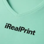 Detaliu personalizare pe tricou damă verde mentă cu anchior în V, logo aplicat prin transfer termic clar pe material din bumbac premium