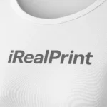 Detaliu logo iRealPrint aplicat prin transfer termic pe bluză damă albă, material din bumbac fin și personalizare clară pe fundal luminos