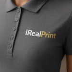 Detaliu logo iRealPrint aplicat prin transfer termic pe tricou polo damă gri metalic cu contrast clar și aspect premium