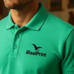 Detaliu logo iRealPrint aplicat prin transfer termic pe tricou polo bărbați personalizat verde mentă, evidențiind claritatea personalizării