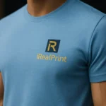 Detaliu logo iRealPrint imprimat pe tricou unisex personalizat albastru azur, transfer termic clar pe material bumbac cu textură fină