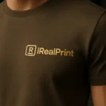 Detaliu personalizare logo iRealPrint pe tricou unisex culoare army, transfer termic clar pe material textil de calitate