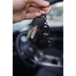 Breloc desfăcător de sticle bicicletă negru folosit pe chei în context real, accesoriu promoțional metalic cu aspect premium și utilizare zilnică