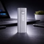 Power bank personalizat argintiu din aluminiu în cadru lifestyle de birou, accesoriu tehnologic promoțional pentru companii moderne și cadouri corporate