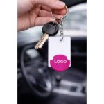 Breloc dreptunghiular cu FISĂ roz personalizat, utilizat pe chei auto, accesoriu promoțional din plastic cu logo vizibil și utilitate practică în supermarket