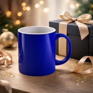 Cana termosensibila albastru lucios pe masa festiva langa cutie cadou eleganta, ilustrand efectul surpriza al unei cani personalizate pentru bauturi fierbinti