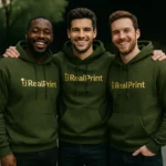 Grup de barbati purtand hanorace verde militar personalizate, imagine de echipa coerenta cu branding vizibil si stil profesionist
