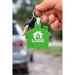 Breloc promoțional verde în formă de casă folosit la chei, imagine lifestyle ce transmite încredere și utilizare zilnică