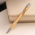 Pix metalic aluminiu personalizat Hello auriu așezat pe agendă pe birou, pix promoțional metalic elegant pentru branding corporate și utilizare profesională zilnică