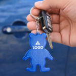 breloc reflectorizant albastru personalizat prins la chei, model ursuleț pentru campanii educaționale și siguranță urbană