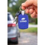 Breloc din plastic personalizat albastru utilizat pe chei auto, accesoriu promoțional cu inel metalic și branding vizibil pentru utilizare zilnică în mediul business