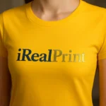 Detaliu personalizare logo iRealPrint aplicat prin transfer termic pe tricou damă personalizat galben, imprimare clară cu contrast puternic