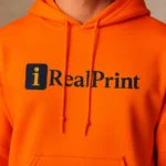Model masculin purtând hanorac personalizat bărbați portocaliu iRealPrint într-un decor urban modern, ilustrând impactul vizual al culorii vibrante