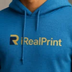 Detaliu hanorac bărbați albastru sapphire cu logo iRealPrint aplicat prin transfer termic profesional, personalizare clară și durabilă pentru branding vizual premium