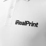 Detaliu personalizare logo iRealPrint aplicat prin transfer termic pe tricou polo bărbați personalizat alb, evidențiind claritatea printului și textura materialului