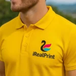 Close-up tricou polo bărbați personalizat galben cu logo iRealPrint aplicat pe piept, evidențiind contrastul puternic și personalizarea profesională