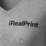 Detaliu personalizare logo pe tricou damă gri închis cu anchior în V, transfer termic clar aplicat pe material bumbac premium