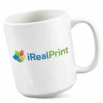 Cană albă personalizată 450ml cu logo iRealPrint prezentată pe fundal alb minimalist, evidențiind forma ceramică și suprafața mare pentru personalizare