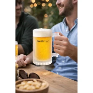Halbă de bere personalizată cu logo iRealPrint ținută în mână într-un cadru de terasă, sugerând momentul de relaxare cu prietenii