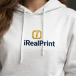Close-up pe hanorac alb cu logo iRealPrint, evidențiind claritatea și contrastul designului