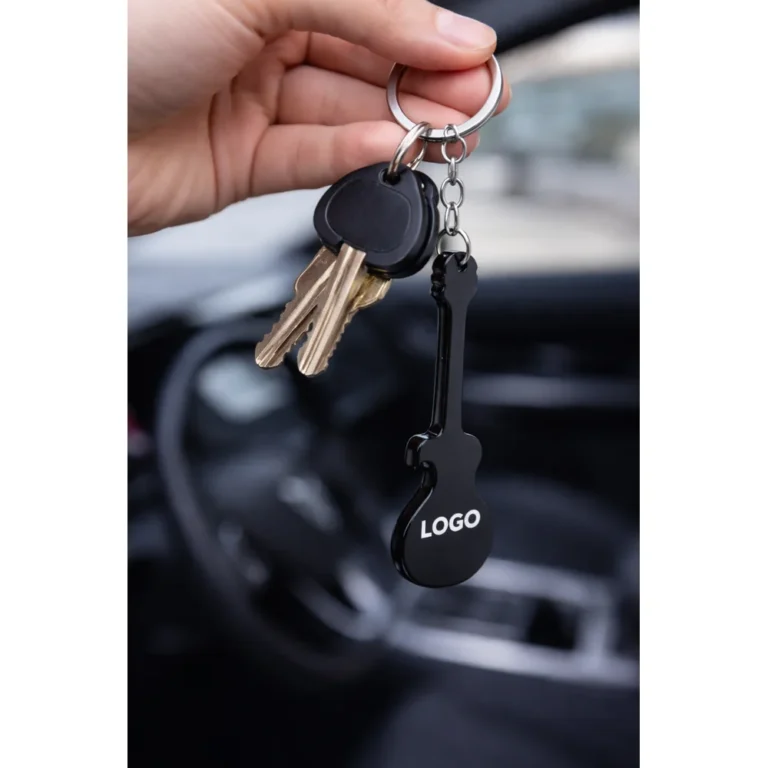Breloc desfăcător de sticle chitară negru folosit pe chei auto în context real, accesoriu promoțional metalic pentru utilizare zilnică și expunere constantă a logo-ului