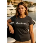Model feminin purtând tricou damă personalizat gri metalic în context urban premium lângă mașină, ilustrând utilizarea modernă