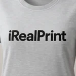 Detaliu personalizare logo iRealPrint aplicat prin transfer termic negru pe tricou damă personalizat gri deschis, evidențiind claritatea și contrastul printului