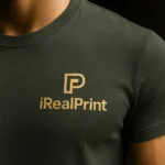 Detaliu tricou unisex personalizat gri ardezie cu logo iRealPrint imprimat prin transfer termic, evidențiind claritatea și calitatea personalizării